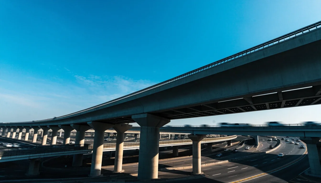 Dubai road interchange seen from a distance at noon with gantries and cut shadows