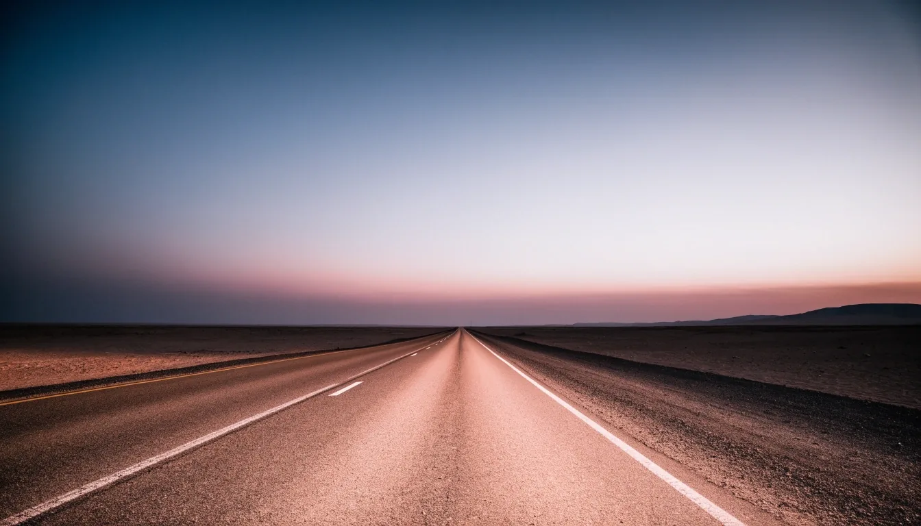 Desert highway at dusk with heat shimmer above the tarmac
